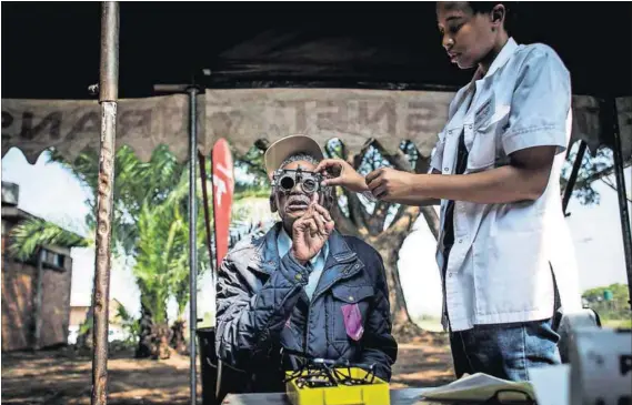  ??  ?? Equal care for all: A man gets his eyes tested outside the Phelophepa mobile health train in Pienaarsri­vier. Health Minister Aaron Motsoaledi (below) envisages a levelling of the healthcare playing fields when the NHI is rolled out. Photos: John...