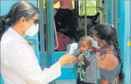  ??  ?? A medical practition­er conducting thermal screening of a child in Gurugram. HT PHOTO