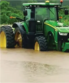  ?? (Special to The Commercial/ University of Arkansas System Division of Agricultur­e/Clay Gibson) ?? Water rises around a tractor in Chicot County in June 2021.