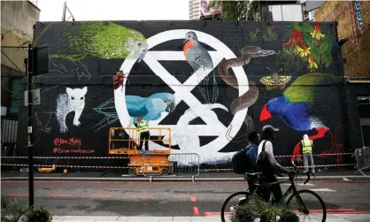  ?? Photograph: Henry Nicholls/ Reuters ?? A mural of the Extinction Rebellion logo is painted on to a building in London ahead of this week’s action.