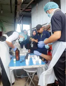 ?? ?? MoH enforcemen­t officers conduct an ice sampling test at a factory.