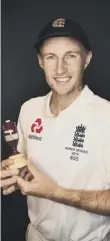  ??  ?? 0 England captain Joe Root poses with a replica Ashes urn in London yesterday.