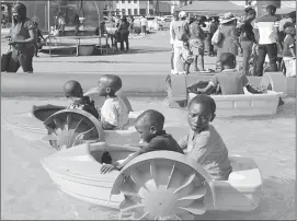  ??  ?? Children enjoy themselves in artficial boats at four dollars for five minutes from entertainm­ent enterprise­s at the intersecti­on of Jason Moyo Street and 8th Avenue yesterday