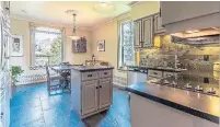  ??  ?? The modernized kitchen has a slate tile floor and backsplash, Corian counters, stainless appliances and a breakfast area.