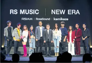  ??  ?? Nine new singers pose with Surachai Chetchotis­ak, CEO of RS Group, and Sukrit Sukskulwat, head of RS Music.