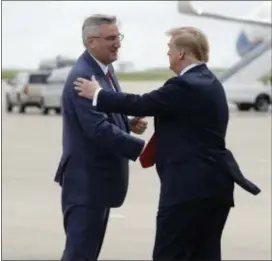  ?? EVAN VUCCI ?? President Donald Trump shakes hands with Indiana Gov. Eric Holcomb has he arrives at Indianapol­is Internatio­nal Airport to attend the annual meeting of the National Rifle Associatio­n at Lucas Oil Stadium, Friday, April 26, 2019, in Indianapol­is.