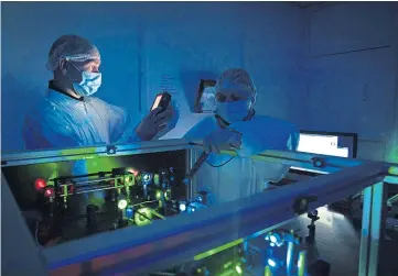  ??  ?? Top: Ceres Holographi­cs chief executive Andy Travers. Above: Senior technician­s Gordon Marwick and Lisa Wood at work in the lab measuring lasers.