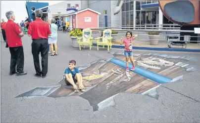  ?? NIKKI SULLIVAN/CAPE BRETON POST ?? Isaac Babin, 8, sits on the ledge in the 3D chalk painting done by Dave Johnston, while his sister, Magali Babin, 6, stands on the ledge.