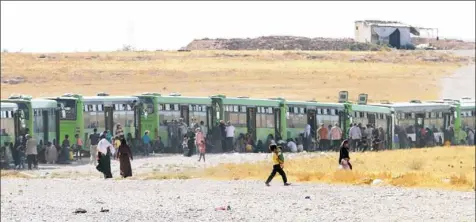  ?? George Ourfalian/AFP/Getty Images ?? Syrian refugees and militants evacuated from northeaste­rn Lebanon are seen Thursday just before crossing into the rebel-held area of Al-Saan in the central Hama province. Thousands of Syrian refugees were bused out of the restive border area between...