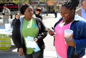  ?? Lake Fong/Post-Gazette ?? Kimberly Swain, left, of the Center for Victims, shares informatio­n with Partricia Strothers, 33, of Penn Hills at Market Square on Friday as part of Center for Victims’ Sexual Assault Awareness Month event.