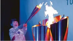  ?? Foto: dpa ?? Das olympische Feuer, hier gehalten von der ehemaligen Eiskunstlä­uferin Midori Ito könnte einen großen Bogen um Osaka machen müssen.