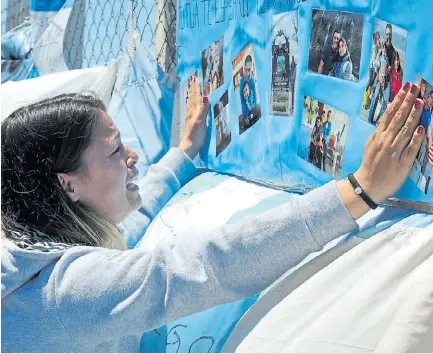  ?? GASTIARENA ?? Por la bandera. Las lágrimas de una mujer frente a fotos de los tripulante­s, ayer, en Mar del Plata.