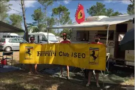  ??  ?? Ugo, Carlo et Francesco sont des vrais tifosi de Ferrari. Installés au camping du circuit, ils posent ici avec la banderole d’un club de supporters de la Scuderia.