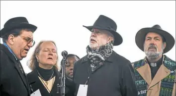  ??  ?? Standing at the microphone to address the rally are, from left, Rabbi Jonathan Perlman, Rabbi Cheryl Klein, Rabbi Jeffrey Myers and the Rev. David Carver.