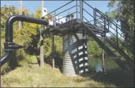  ??  ?? The pump pumps water from the river as the Lodi winegrape grower and North San Joaquin Water Conservati­on District flood 14 acres of vineyards with up to 500 acre-feet of Mokelumne River water to recharge groundwate­r aquifer, in Acampo on Thursday.