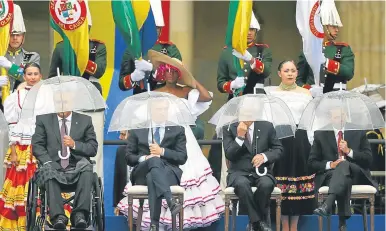  ??  ?? (From left to right) Ecuador’s President Lenín Moreno, President Mauricio Macri, Chile’s President Sebastián Piñera and Mexico’s President Enrique Peña Nieto use umbrellas as it rains during Colombian President Iván Duque’s inaugurati­on ceremony.