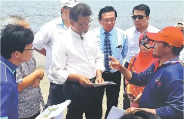  ??  ?? Dr Xavier (third left) being briefed by a fishermen on the king tide that flooded the landing place for fishermen and the Kuala Baram road and caused soil erosion.