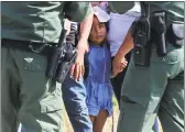  ?? Jerry Lara / San Antonio Express-News ?? Border Patrol agents question a group of adult and minor immigrants near Anzalduas Park, southwest of McAllen, Texas.
