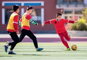  ??  ?? Le 18 mai 2020, des élèves de l’école primaire de la rue Hengchangd­ian dans le district de Yuquan, à Hohhot (Mongolie-intérieure) jouent au football en classe de sport.