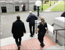  ?? The Canadian Press ?? The B.C. legislatur­e’s sergeant-at-arms, Gary Lenz, centre, is escorted out of the legislatur­e Tuesday by security. Lenz and Craig James, the clerk of the house, were placed on indefinite leave Tuesday.