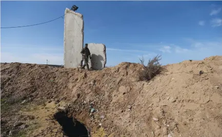  ??  ?? A HAMAS MEMBER walks near a collapsed tunnel on the border with Egypt in 2015.