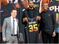  ?? (AP photo/Matt York) ?? Phoenix Suns forward Kevin Durant, center, holds his jersey Thursday after being introduced during an NBA basketball team availabili­ty by owner Mat Ishbia, left, and general manager James Jones in Phoenix.
