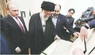  ??  ?? TEHRAN: Iranian Supreme Leader Ayatollah Ali Khamenei looks at a copy of the Holy Quran presented by Russian President Vladimir Putin (left) during their meeting yesterday. — AP