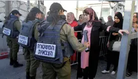  ??  ?? Photo ci-dessus : Contrôle de femmes palestinie­nnes par l’armée israélienn­e au checkpoint entre Bethléem (Cisjordani­e) et Jérusalem, tandis qu’elles se rendent à la mosquée d’Al-Aqsa, pour le premier vendredi de prière du Ramadan, le 18 mai 2018. Capitale à la fois politique et religieuse pour les Israéliens comme les Palestinie­ns, Jérusalem est au coeur de l’affronteme­nt entre les deux peuples. (© Musa Al Shaer/AFP)