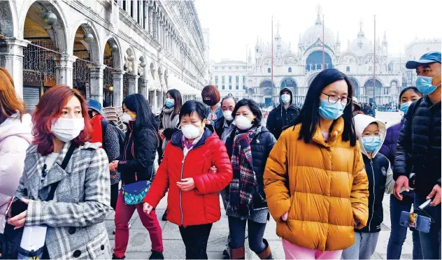  ?? Agence France-presse ?? ↑
Tourists, wearing masks, visit the Piazza San Marco in Venice on Monday.