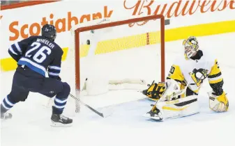  ?? John Woods / Associated Press ?? Winnipeg right wing Blake Wheeler fires the puck past Pittsburgh goalie Matthew Murray, one of Wheeler’s three first-period goals. He added a third-period assist in the Jets’ 7-1 win.