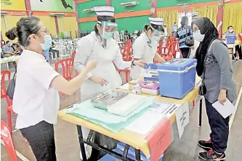  ??  ?? Frontliner­s preparing for the vaccinatio­n simulation carried out by the Serian Health Office at Dewan Masyarakat Serian yesterday. - Bernama photo