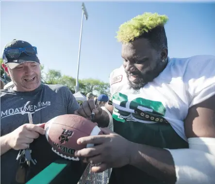  ?? KAYLE NEIS ?? Saskatchew­an Roughrider­s offensive lineman Derek Dennis, signing an autograph for a fan, will resume acquaintan­ces with his former Stampeders teammates on Saturday night at McMahon Stadium. Dennis signed with the Riders after an outstandin­g season in...