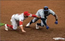  ?? AARON DOSTER / AP ?? Cincinnati Reds first baseman Joey Votto dives and tags out Cleveland Indians’ Franmil Reyes during a triple play during the eighth inning Saturday in Cincinnati. The play started when Votto snagged a line drive by Josh Naylor and ended when he fired the ball to third for the final out on a baserunner who had broken for home.