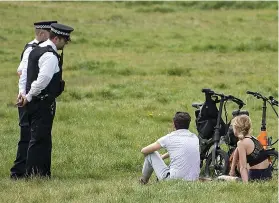  ??  ?? Holiday crowds in Richmond Park in south-west London yesterday, where police were on hand to ensure they were there for exercise and not sunbathing. Right, the same message in Brighton