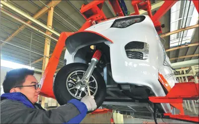  ?? WANG JILIN /FOR CHINA DAILY ?? A technician works on the assembly line of an electric vehicle manufactur­er in Weifang, Shandong province.