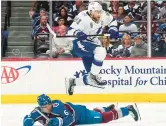  ?? JOHN LOCHER/AP ?? Lightning center Steven Stamkos (91) jumps over Avs defenseman Erik Johnson during Game 1 of the Stanley Cup Final on Wednesday in Denver.