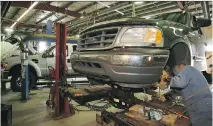  ?? RICK MACWILLIAM ?? Mechanic Frank Jansen works on a pickup at Art Barry Ford in Edmonton. Customers prefer dealers until their warranties end.