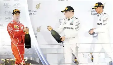  ?? ANDREJ ISAKOVIC/AFP ?? Ferrari’s Sebastian Vettel (left) celebrates on the podium with Mercedes’ Valtteri Bottas (centre) and Lewis Hamilton after winning the Bahrain Grand Prix on April 16.