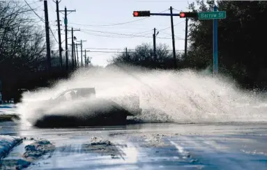  ?? RONALD W. ERDRICH, THE ABILENE REPORTER-NEWS VIA AP ?? A pickup sends a wake of snow melt high into the air in Abilene, Texas.