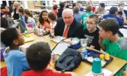  ?? THE ASSOCIATED PRESS ?? Agricultur­e Secretary Sonny Perdue eats lunch Monday with students in the cafeteria at Catoctin Elementary School in Leesburg, Va.