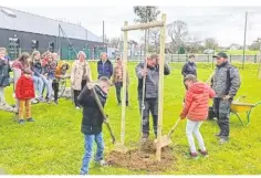  ?? ?? Symbolique­ment, les élèves, comme ici Liam et Julia, se sont succédé pour planter l’arbre en présence du Maire, Lyne Delaunay et de son adjointe Isabelle Lottin.
