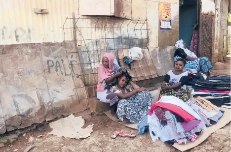  ?? CHAMSIDINE/AP SONY IBRAHIM ?? Women sell clothes Feb. 6 in Mamoudzou, Mayotte, a French territory. The island was last in the European Union to get vaccines.