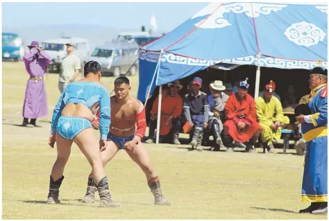  ?? McCLATCHY PHOTOS ?? LOCAL TRADITION: Two wrestling contestant­s face off at the Nadaam festival in Karakorum, Mongolia. At top, the views of lake Terkhiin Tsagaan Nuur are spectacula­r in Khorgo-Terkhiin Tsagaan Nuur National Park.