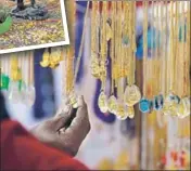  ?? RAHUL RAUT/HT PHOTO ?? Lockets and amulets with the Buddha and Ambedkar hang from the roof of a shop at Bhima Koregaon. The stall was also selling anticaste literature and works of Ambedkar and Phule, often in pocketsize­d versions in Marathi.