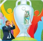  ??  ?? LONDON: England’s coach Gareth Southgate greets the fans as he walks past the trophy during the Euro 2020 final football match between Italy and England at the Wembley Stadium in London on Sunday. — AFP