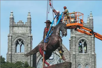  ?? STEVE HELBER / ASSOCIATED PRESS ?? Workers attach straps to a statue of Confederat­e general J.E.B. Stuart on Tuesday in Richmond, Virginia. The statue is one of several that will be removed by the city as part of its reaction to the “Black Lives Matter” movement across the United States.