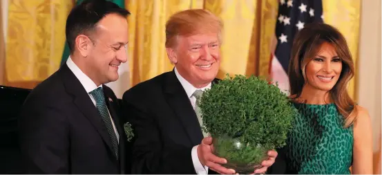  ??  ?? Taoiseach Leo Varadkar presents US President Donald Trump with a bowl of shamrock as First Lady Melania Trump looks on.