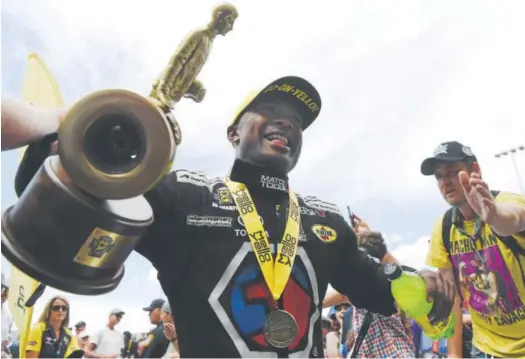  ?? Photos by Andy Cross, The Denver Post ?? Antron Brown celebrates with fans Sunday after winning the top fuel division at the NHRA’s 38th annual Mile-High Nationals at Bandimere Speedway in Morrison. Brown defeated Don Schumacher Racing teammate Leah Pritchett in the final.