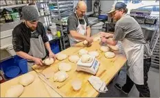  ?? Jim Franco / Times Union ?? From left, Max Rivet, Leigh Rathner and Brendon Griffin work dough at Night Work Bread in Ballston Spa.