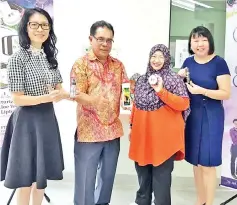  ??  ?? Jacqueline (second right) showing the various Adamia Cosmetics products to Mohd Basri (second left). Also seen is FSI vice president (membership, KPI, IT & services) Natalie Fung (right).
